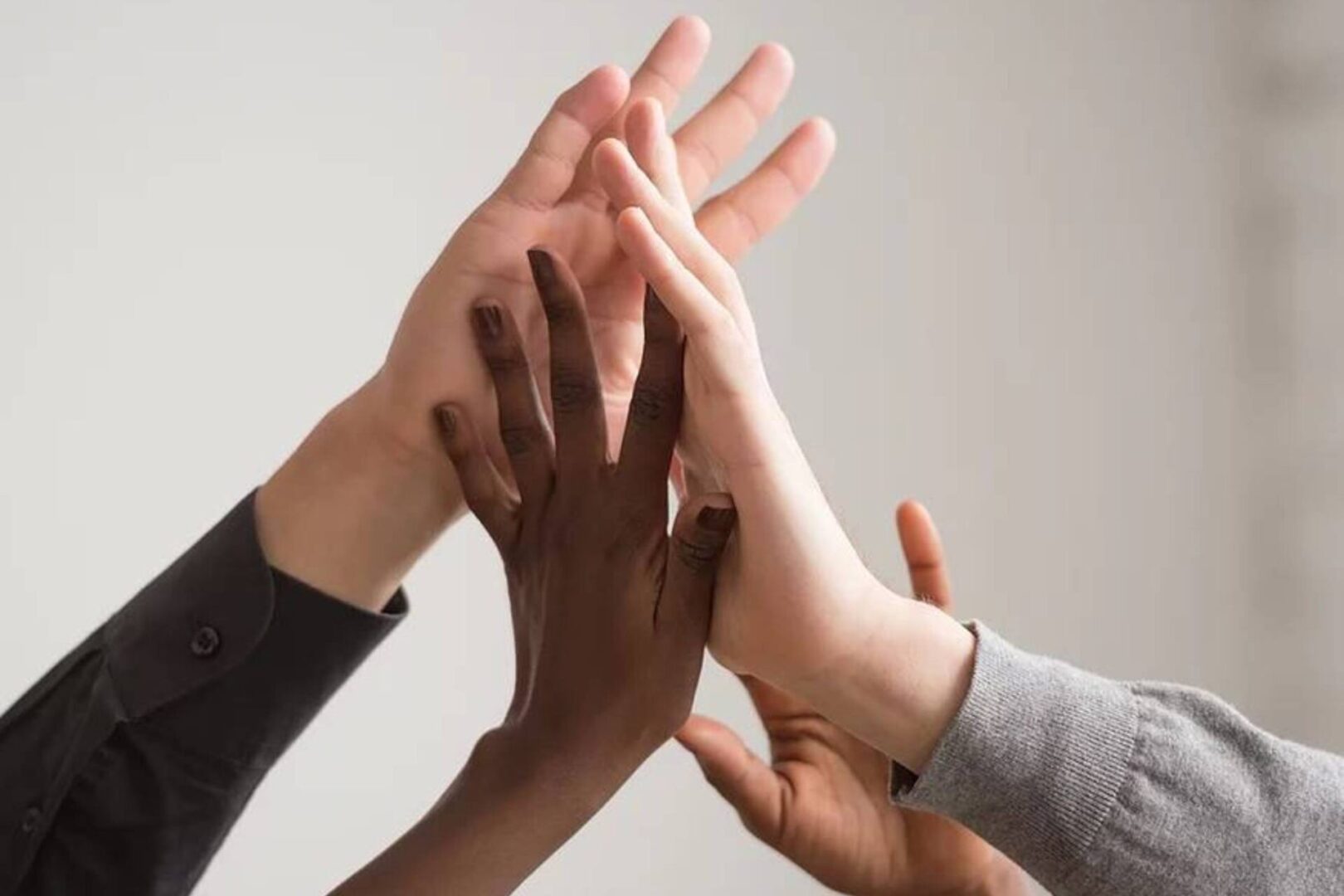 A group of people with their hands together.