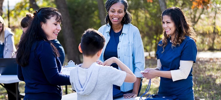 A woman and two children are standing outside.