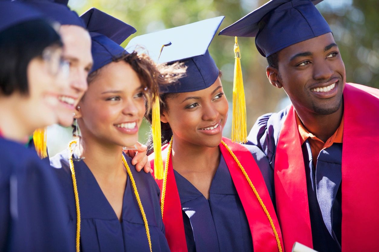 A group of people in graduation attire standing next to each other.