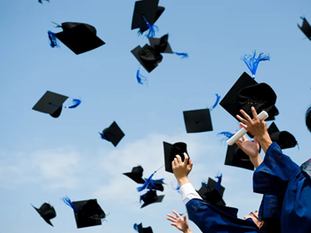 A group of people throwing their graduation caps in the air.