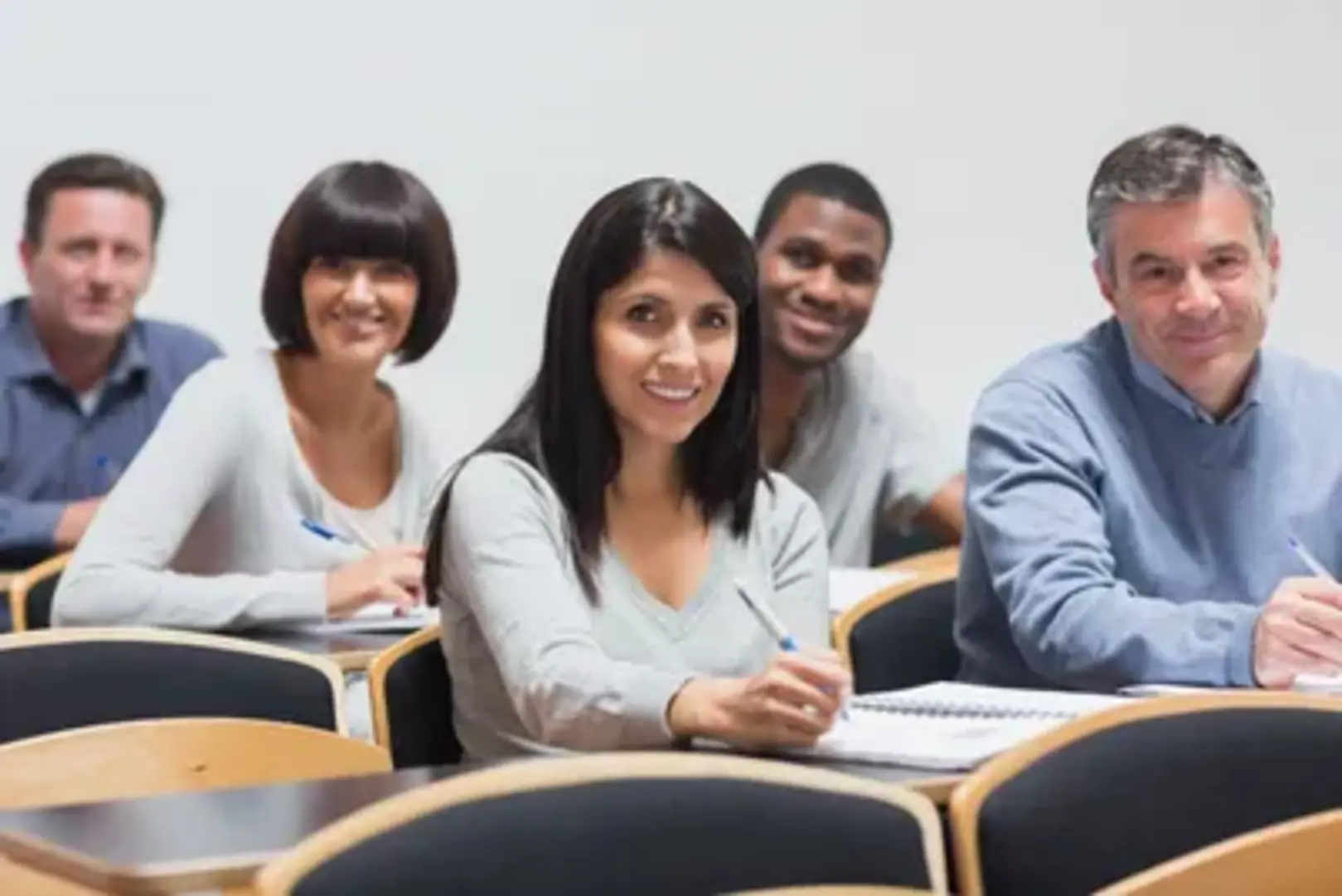 Students sitting in a classroom, taking notes.